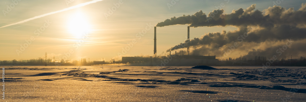 Smoke from industry plant chimney over sunrise sky background. Energy generation and air environment pollution industrial pipe scene. Wide banner