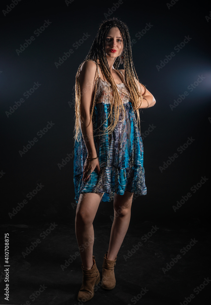 Portrait of a charming girl with braids with a mystic look at the camera. Studio black background.. Portrait of a charming girl with braids with a mystic look at the camera. Studio black background..