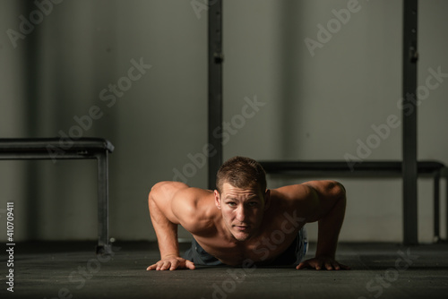 Strong male athlete doing push-ups indoors. Close up perspective  healthy lifestyle  fatless body.
