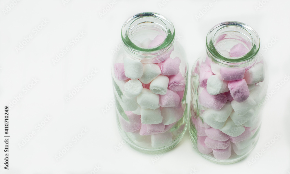 Sweet jelly beans in glass bottles on white background Sweet jelly beans in glass bottles on white background