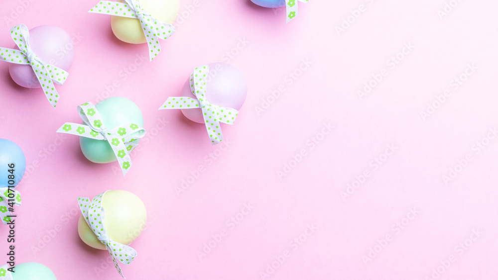 Easter pattern. Colorful egg with tape ribbon on pastel pink background in Happy Easter decoration. Spring holiday top view concept.