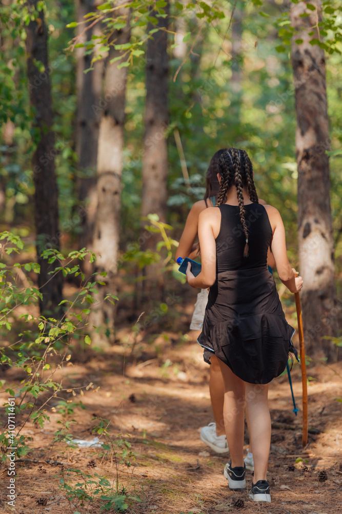 Two female caucasian friends hiking in the woods on a mountain on a nice sunny day. Two female caucasian friends hiking in the woods on a mountain on a nice sunny day.