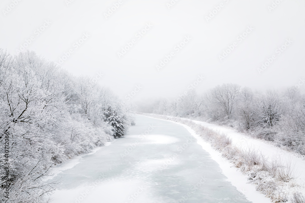 Obraz premium The Hennepin Canal in Illinois on a Snowy and Foggy Winter Day