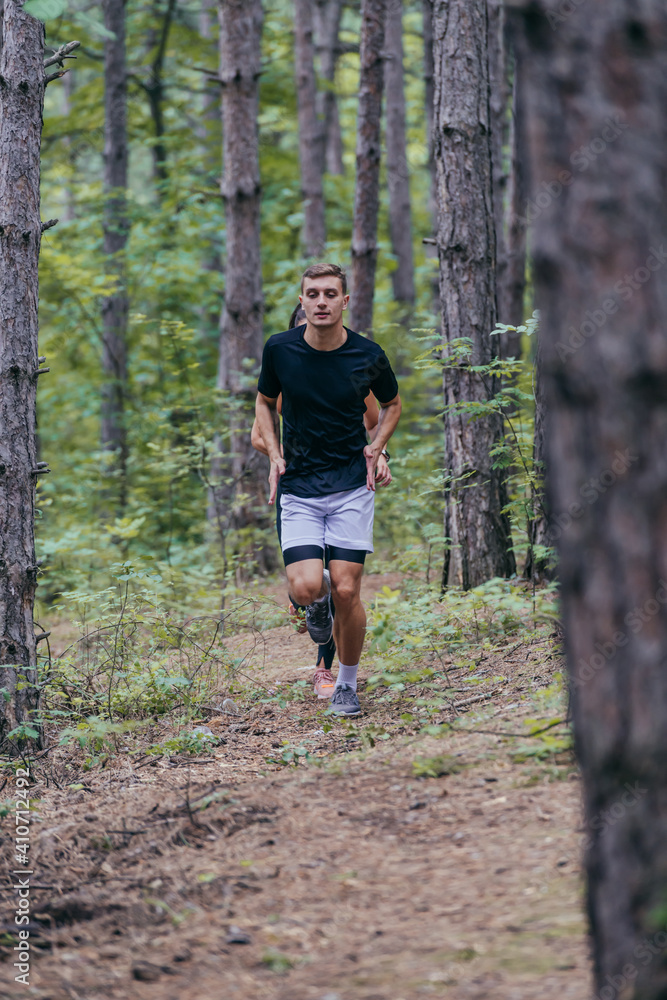 Full-length picture of an attractive male athlete running in the woods Full-length picture of an attractive male athlete running in the woods