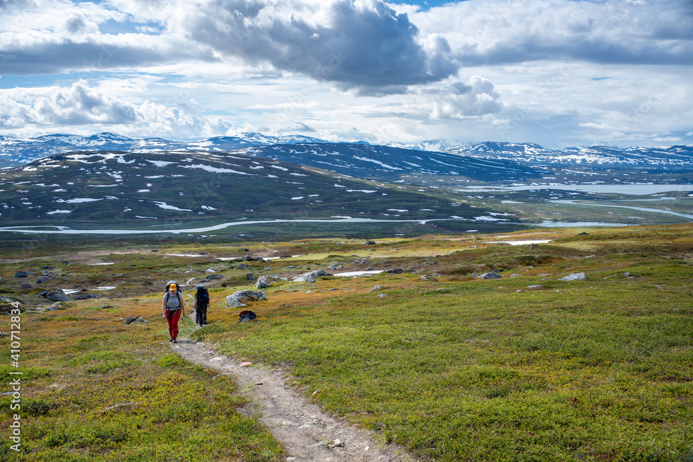 Padjelanta National Park, Beautiful Mountain Scenery and Hiking Trails leading away from Camera with group of hikers trekking and living the wanderlust dream.