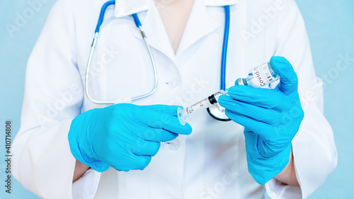 Discovery of a vaccine against coronavirus infection. COVID-19 vaccine testing and trial. Coronavirus vaccination concept banner. Doctor's hands are taking a vaccine into a syringe close-up.