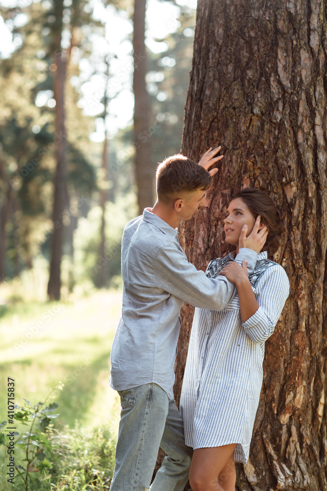 Young couple in love hugging near trees in summer park. pretty woman and man, wearing in denim outfit are having fun and have date outdoors. Romantic relationship. valentines day Young couple in love hugging near trees in summer park. pretty woman and man, wearing in denim outfit are having fun and have date outdoors. Romantic relationship. valentines day