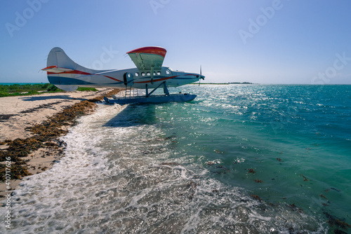 Fotografi Small hydroplane sitting on a beach of an island