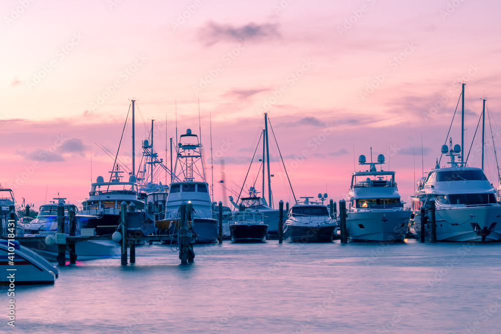 Ships parked in a row in a port of Key West during sunset. Red glowing sky, past golden hour.