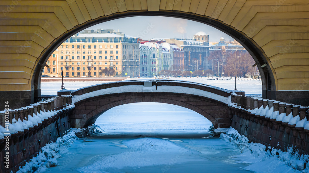Arch and bridge connecting the Winter Canal and the Bolshaya Neva river. Sights of St. Petersburg. Winter in the city on the Neva in Russia
