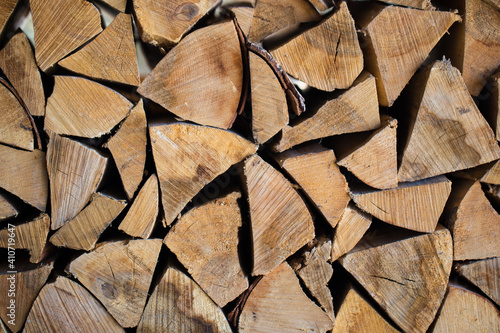 Stacked firewood close-up. Firewood storage close up. Stocks of wooden logs close-up. Chopping wood. Logging in the village.