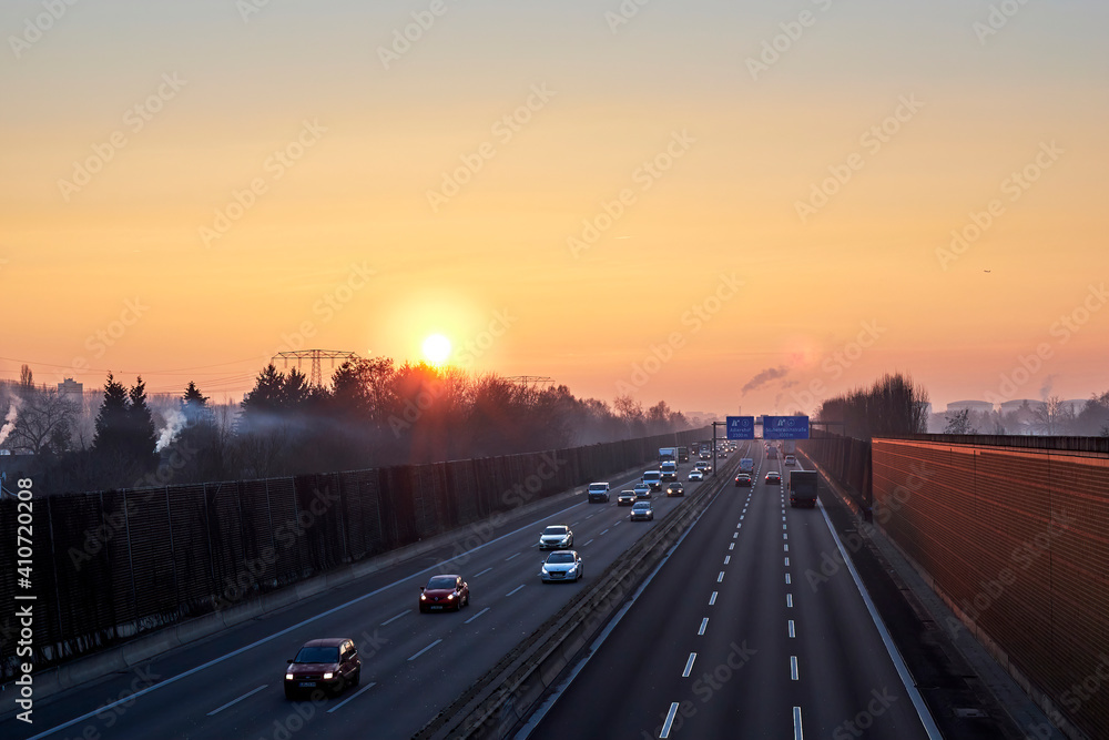 Sunrise over a highway in Berlin on a foggy morning with intense orange sunlight Sunrise over a highway in Berlin on a foggy morning with intense orange sunlight