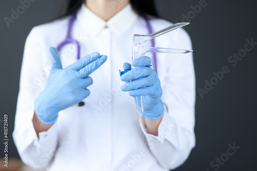 Gynecologist holds an instrument for examining women