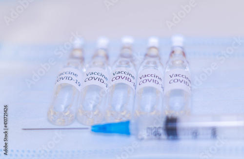 ampoules with Covid-19 vaccine on a laboratory on the table, syringe