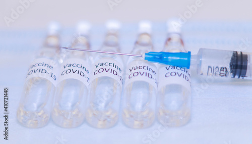 ampoules with Covid-19 vaccine on a laboratory on the table, syringe