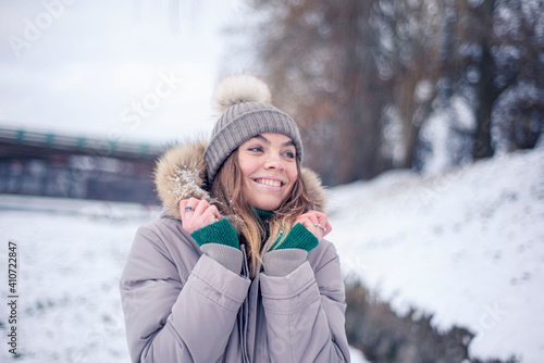 woman in winter park  Girl in a winter jacket in winter  happy woman laughs  positive emotions
