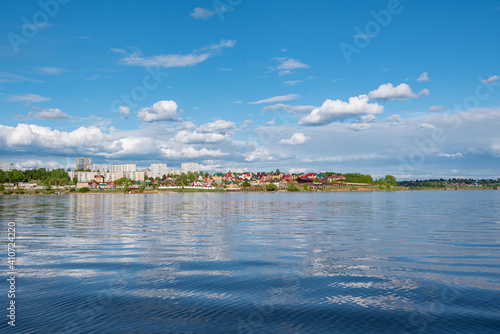 View from the river to the city of Dobryanka, Perm krai, Russia, Kama River blue sky with clouds, reflection in the water. photo