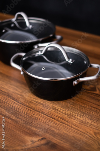 Set of grill pans on wooden table against black background  space for text