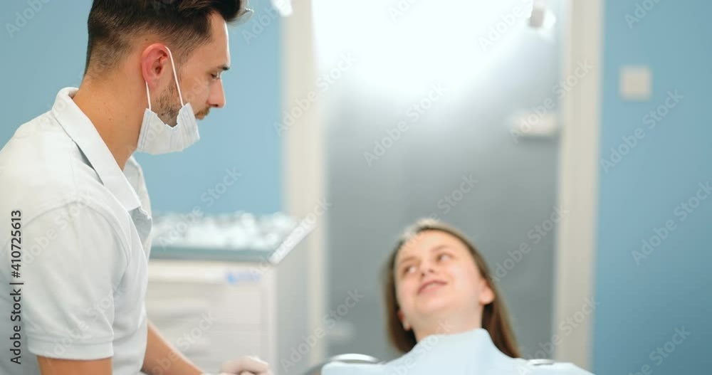 Small talk between patient and dentist, preparing for the dental check up at the dental office. Regular visit to the orthodontist Small talk between patient and dentist, preparing for the dental check up at the dental office. Regular visit to the orthodontist