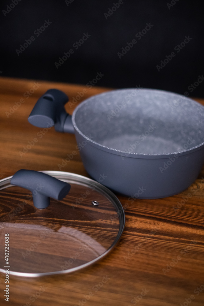 Set of grill pans on wooden table against black background, space for text Set of grill pans on wooden table against black background, space for text