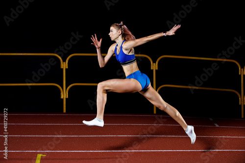 Sprinter girl jumps on track running training