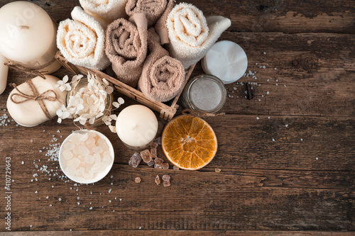 Spa composition with candles, soap and napkins on a brown wooden background. Top view, with space to copy.