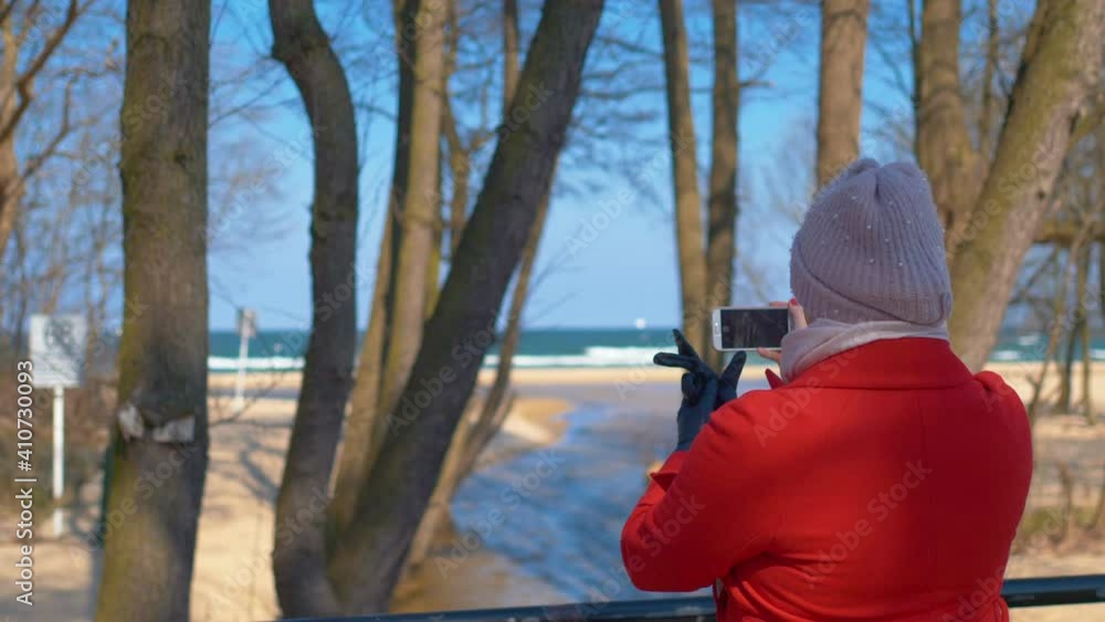 Woman taking picture of coastline in winter in 4k slow motion 60fps Woman taking picture of coastline in winter in 4k slow motion 60fps