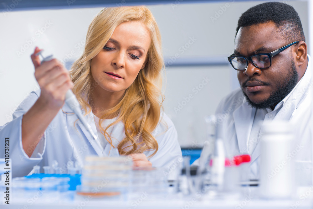 Professional team of scientists is working on a vaccine in a modern scientific research laboratory. Genetic engineer workplace. Future technology and science. Professional team of scientists is working on a vaccine in a modern scientific research laboratory. Genetic engineer workplace. Future technology and science.