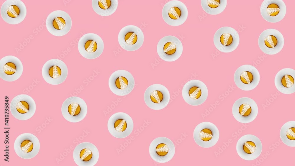 seamless looping animation with slices of yellow round biscuit decorated by white cream that wiggle on a pink background. abstract food backdrop with copy space seamless looping animation with slices of yellow round biscuit decorated by white cream that wiggle on a pink background. abstract food backdrop with copy space