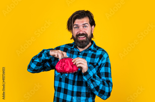 smiling man holding an wallet with money, saving concept