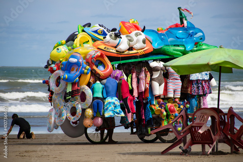 Vendedor de artículos de playa coloridos cerca del mar photo