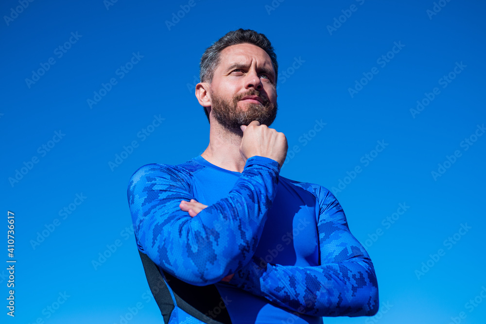athletic muscular man in sportswear on sky background, trainer