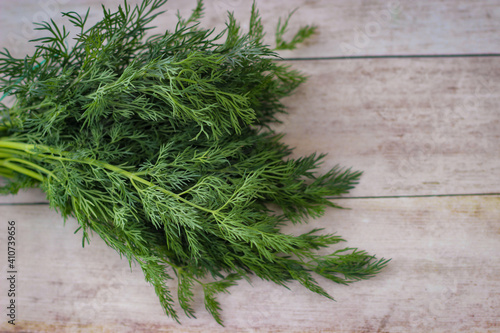 Green dill leaves on a wooden background