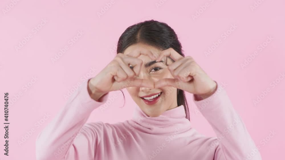 Beauty concept of 4k Resolution. A beautiful woman staring at the camera on a pink background.