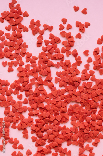 Abstract pink background with red sugar hearts. Valentine's day background.