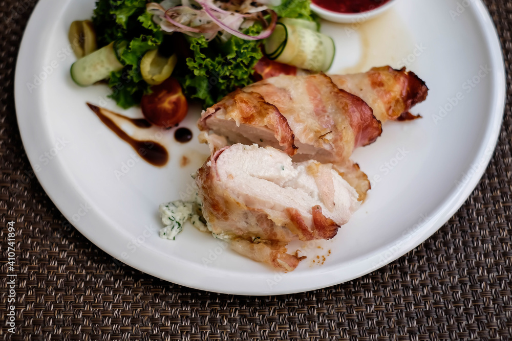 Chicken breast stuffed with cheese sauce and wrapped in pancetta bacon.
