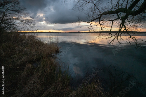 Caspar David Friedrich style atmosspheric picture of a meadow landscape at winter sunset on the shores of Grosser Zernsee in Werder Brandenburg Germany photo