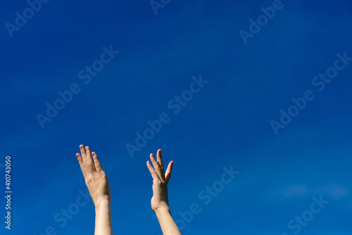 I wish we could touch the sky, female stretching hands to blue sky
