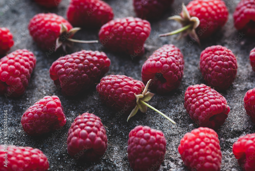 Raspberries food background - ripe harvested raspberry arranged on gray stone texture Raspberries food background - ripe harvested raspberry arranged on gray stone texture