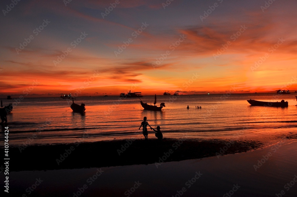 Tropical romantic paradise: sunset at the seaside - dark silhouettes of palm trees