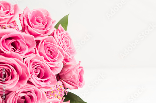 Beautiful bouquet of pink roses flowers with white bow for holiday gift