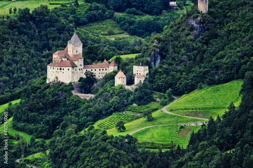 Aerial shot of the Trostburg castle surrounded by trees on the mountain of South Tyrol in Italy photo