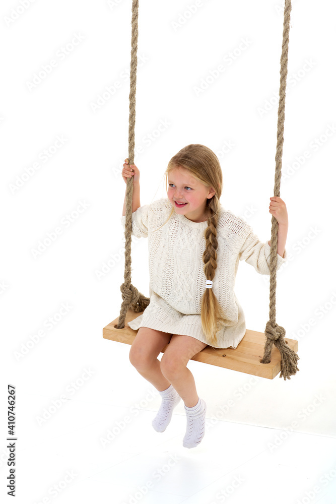 Cute long haired girl sitting on rope swing