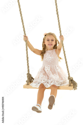 Beautiful girl swinging on wooden swing