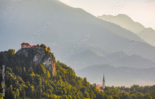 Bled Castle on a Rock Cliff at Bled Lake in Slovenia with Silhouette of Mountains in Background