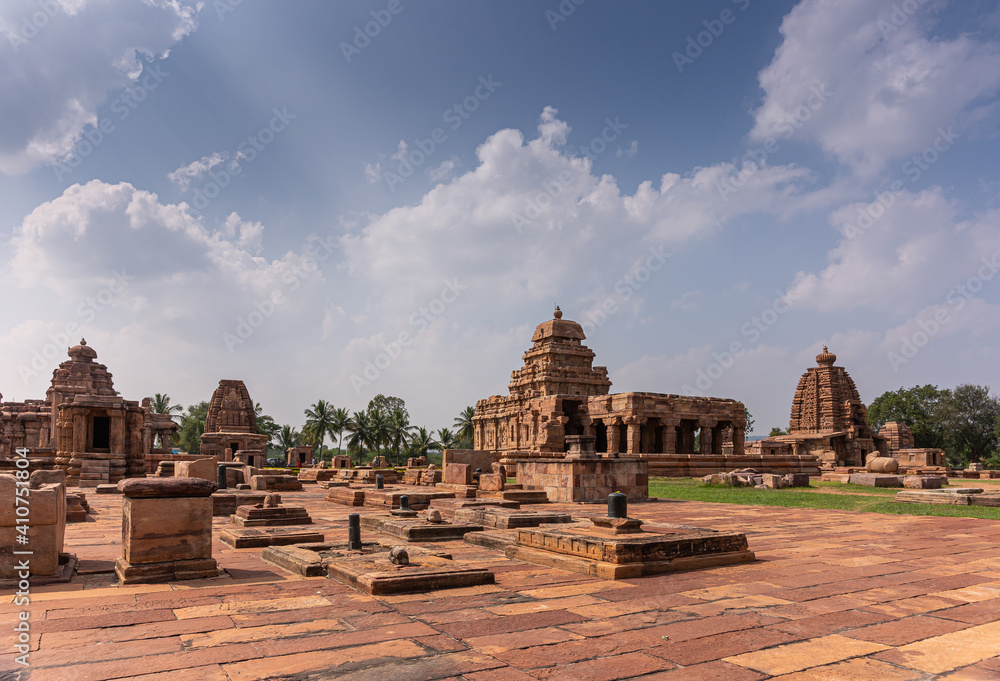 Bagalakote, Karnataka, India - November 7, 2013: Pattadakal temple complex. Brown stone landscape of brown stone Sanganeshwar, Galagnatha, and other temples under blue cloudscape,