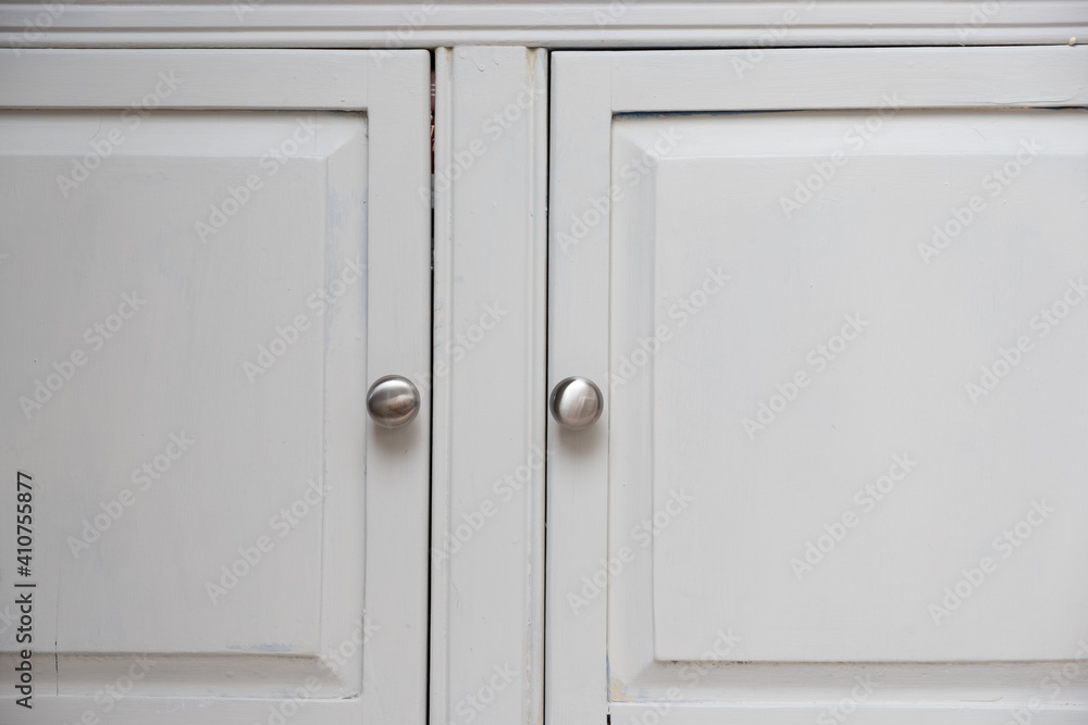 Obraz premium Silver knobs on white cabinet doors on an American Home Kitchen