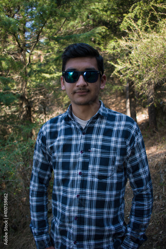 picture of indian boy standing outdoor in forest and hands in pocket