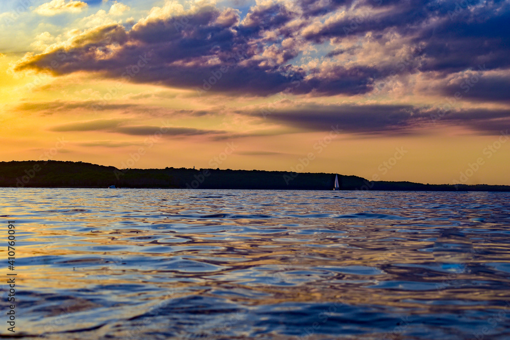 A sailboat overlook a vibrant beautiful sunset