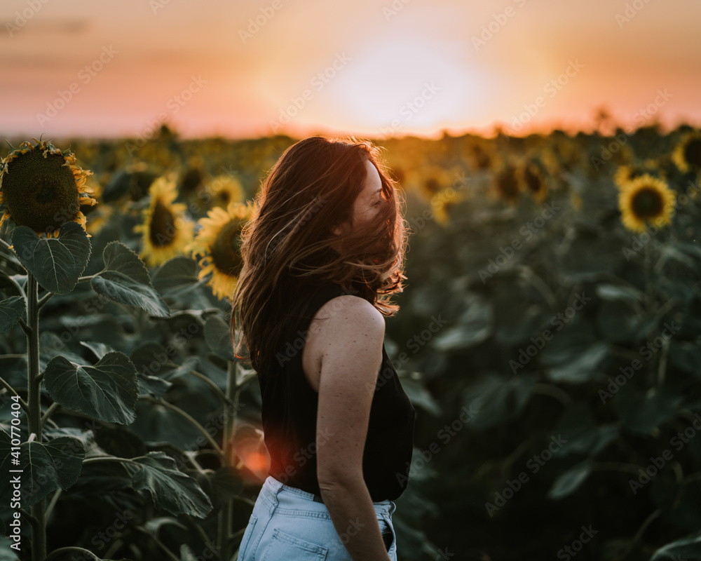 Φωτογραφία Happy woman in field with sunflowers on sunset background